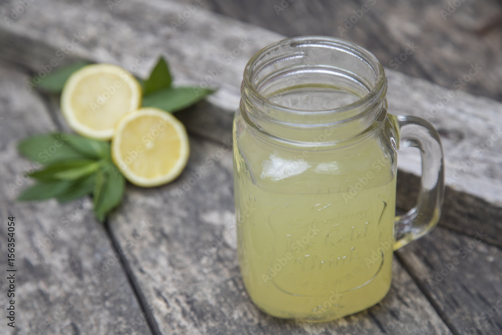 Lemon juice in jar, decorated with fresh lemons and mint leaves. Lemon juice in jar, decorated with fresh lemons and mint leaves.