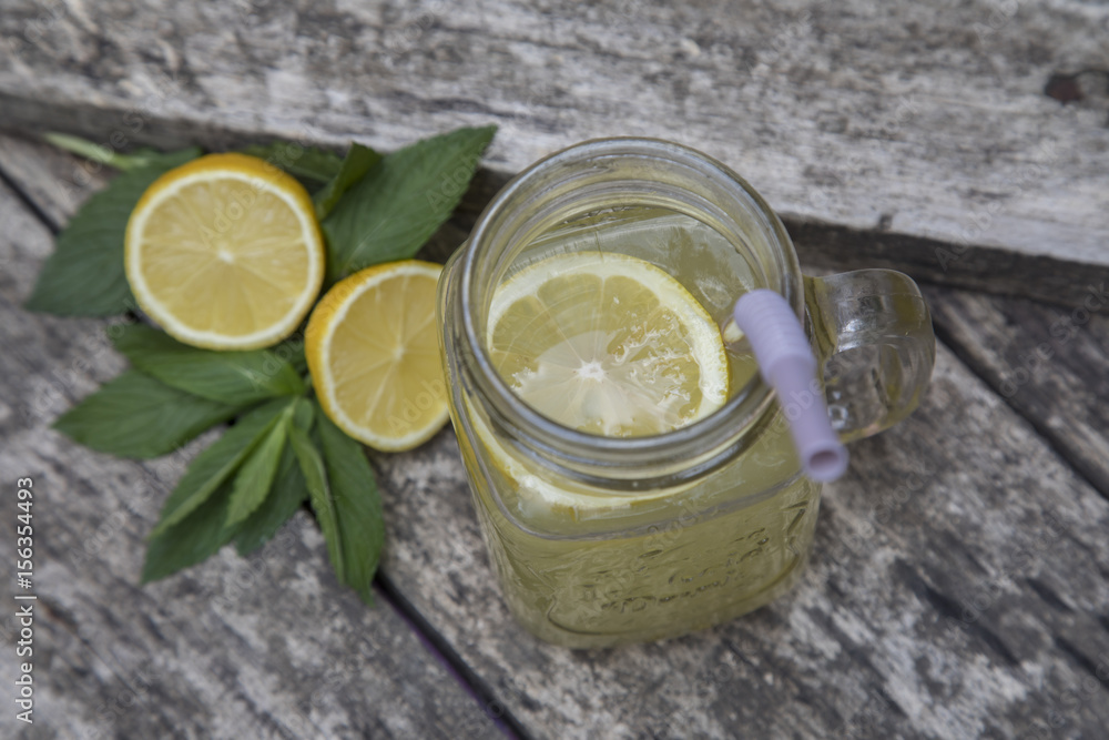 Lemon juice in jar, decorated with fresh lemons and mint leaves. Lemon juice in jar, decorated with fresh lemons and mint leaves.