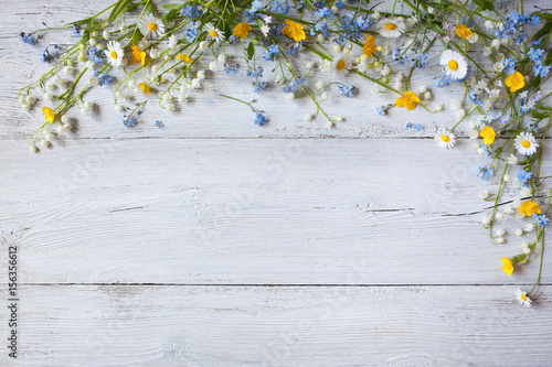 Spring flowers of lilies of the valley, forget me not, daisies on a white  wooden background photo