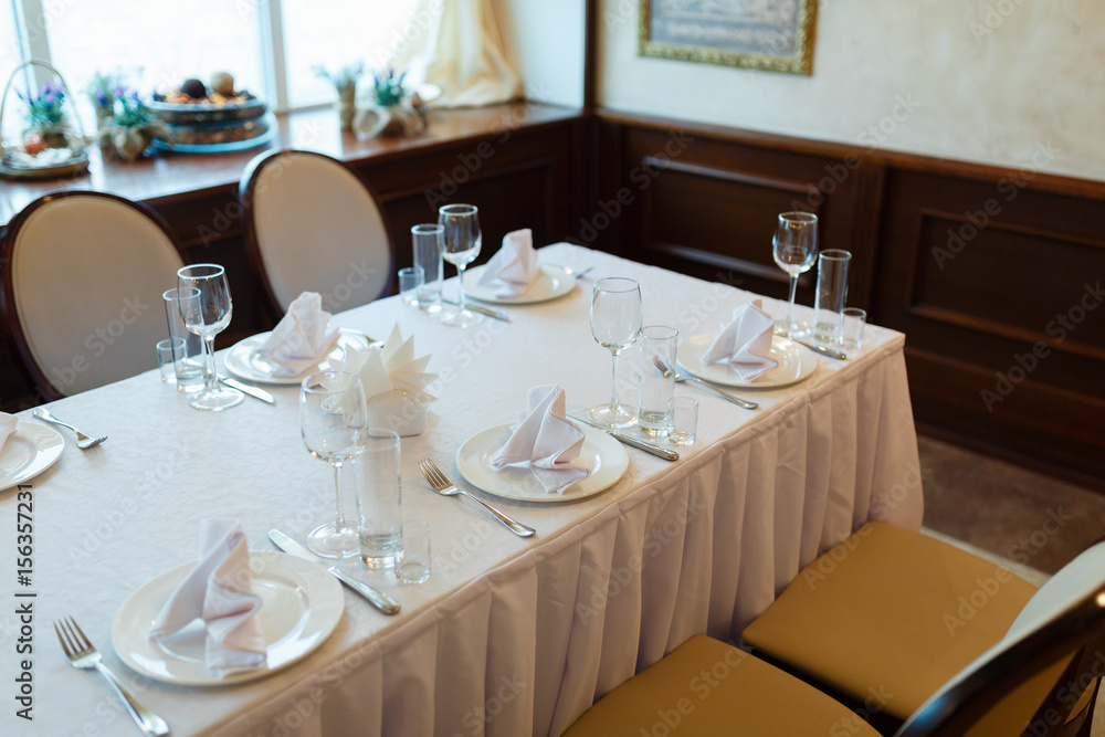 Plate with fork, knife and napkin served on the wedding table, all ready for the holiday.