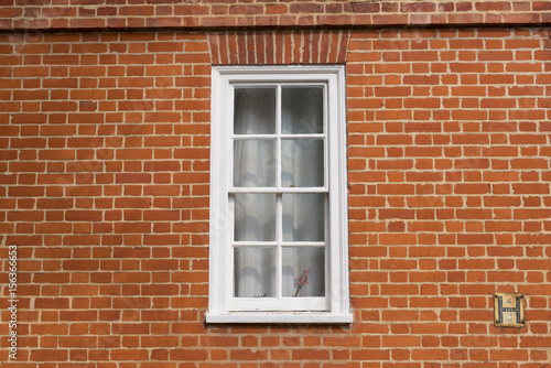 White vintage wooden window on a restored red brick wall
