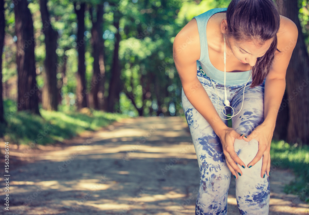 Female athlete runner touching knee in pain, fitness woman running in park. Female athlete runner touching knee in pain, fitness woman running in park.
