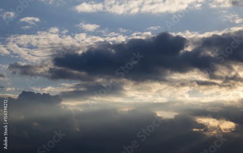 Cumulus clouds with sun rays, dramatic sky © yauhenka