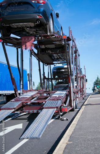 Two levels car hauler semi truck unloading cars