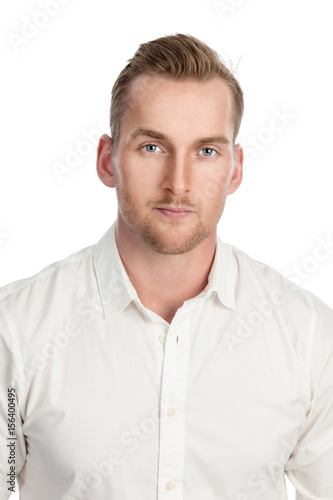 Handsome tan blonde man standing against a white background, wearing a white dress shirt.
