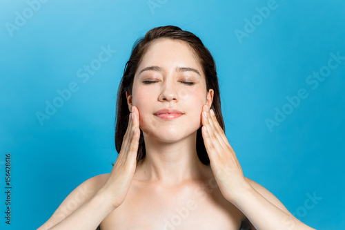 young beauty woman massaging her face. facial massage concept. photo