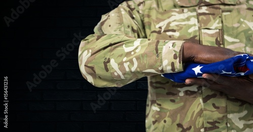 soldier with USA flag in the hands, dark background
