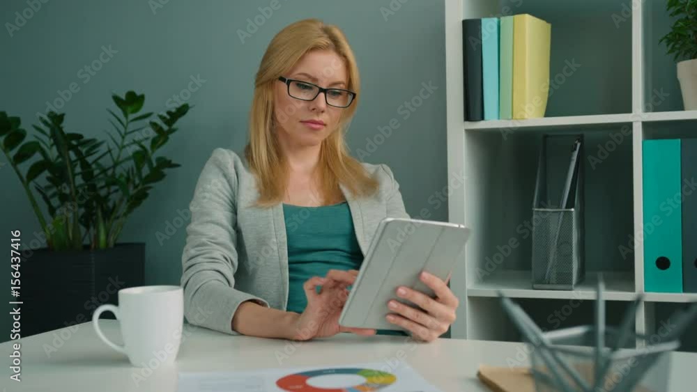 Beautiful businesswoman working with tablet computer and thinking at the office Beautiful businesswoman working with tablet computer and thinking at the office