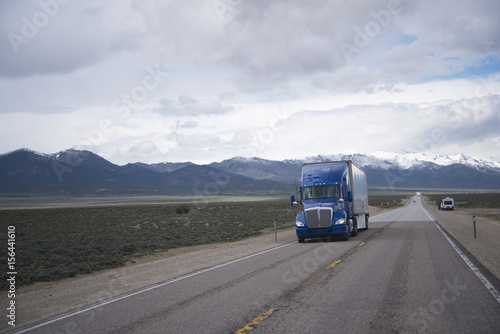 Blue semi truck on straight road on Nevada plateau