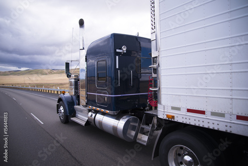 Custom big rig dark blue semi truck with reefer trailer