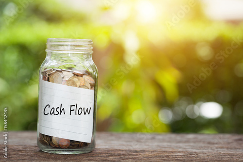Photography coin in jar with cash flow text, Financial Concept.