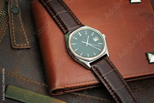 Vintage watch on a brown leather wallet. Classic Wristwatch. (Vintage Style Color Process)