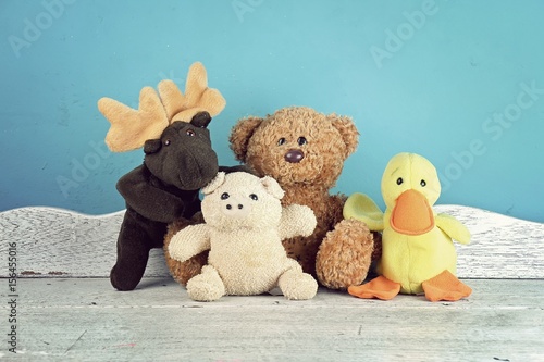 Fotografiet Group of stuffed animal toys on the white wooden table, Animal dolls, Friendship concept