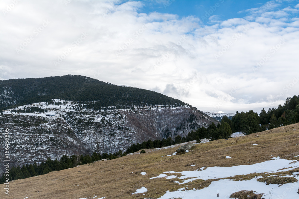 Fototapeta premium Winter Pyrenees landscape: snow-covered meadow and icy mountain peaks on background, Pyrenees, Spain