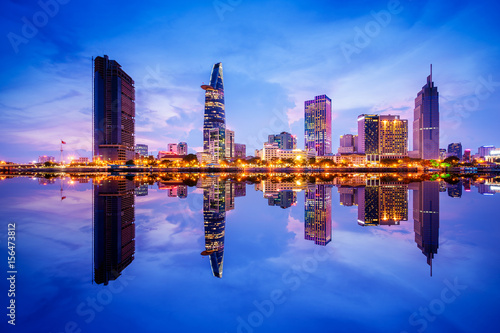 Cityscape in reflection of Ho Chi Minh city at beautiful twilight, viewed over Saigon river. Hochiminh city is the largest city in Vietnam with population around 10 million people