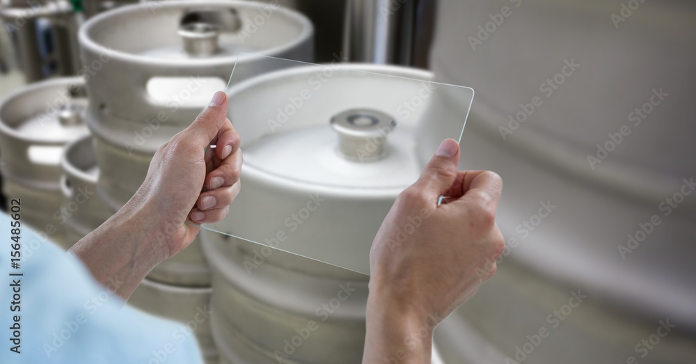 Cropped hands photographing kegs through 