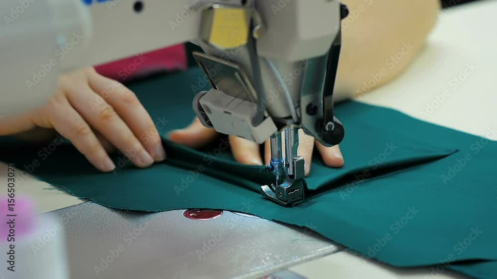 Close-up female sews clothes at the garment factory Close-up female sews clothes at the garment factory