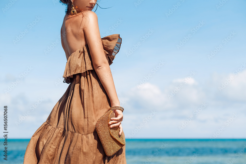 Fototapeta premium beautiful young woman in elegant dress on the beach