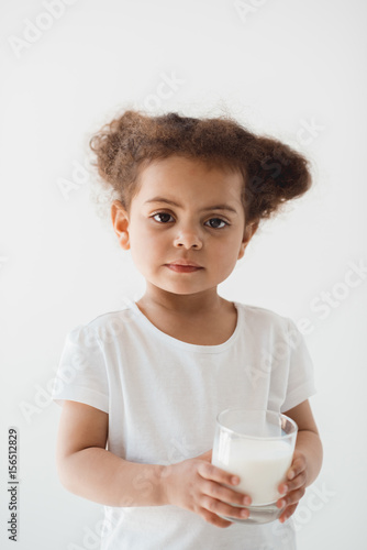 cute little kid girl holding glass of milk isolated on white
