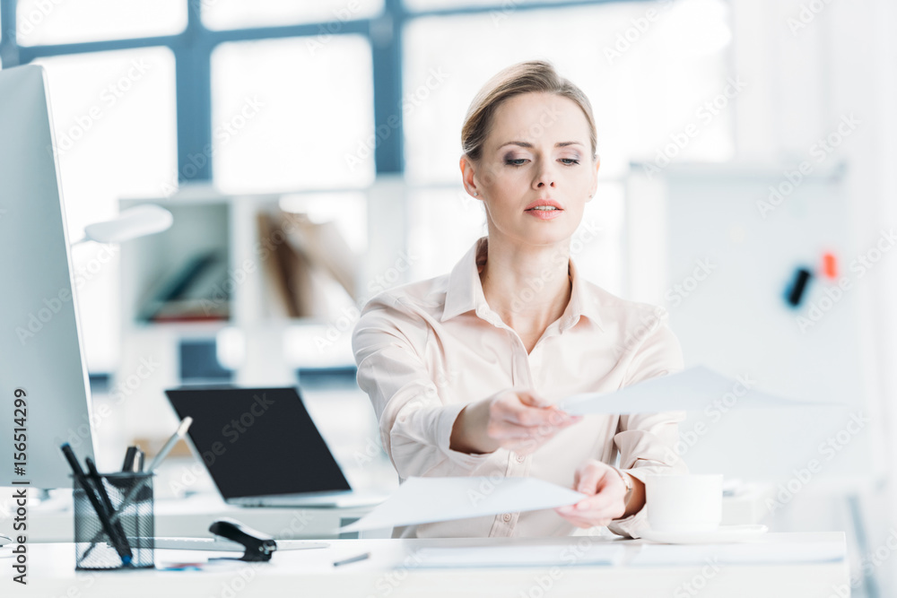 young caucasian businesswoman working with documents while sitting at office young caucasian businesswoman working with documents while sitting at office