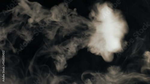 Vapor like smoke at sepia on a dark black background. Vape smoke rings in motion at vape clouds.