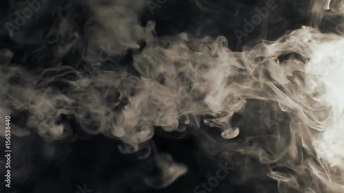 Vapor like smoke at sepia on a dark black background. Vape smoke rings in motion at vape clouds.