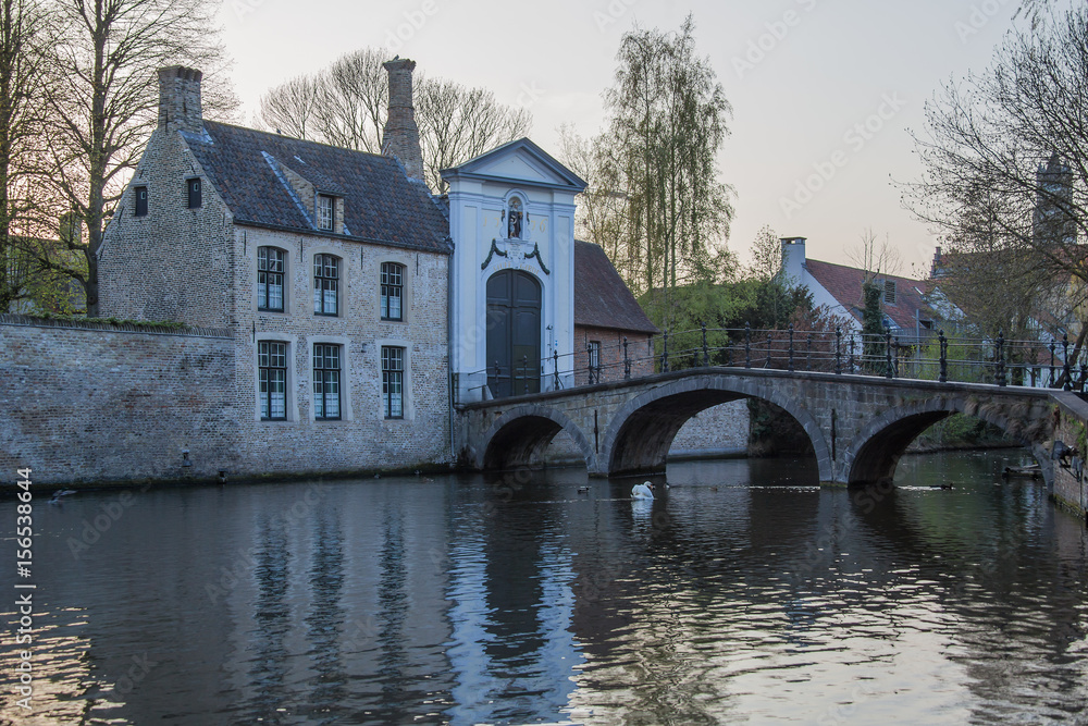 View on Begijnhof monastery from old bridge in Minnewater park at quiet spring evening in Bruges (Brugge), Belgium View on Begijnhof monastery from old bridge in Minnewater park at quiet spring evening in Bruges (Brugge), Belgium