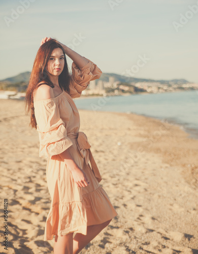  Beautiful woman posing in boho style beach dress near the sea