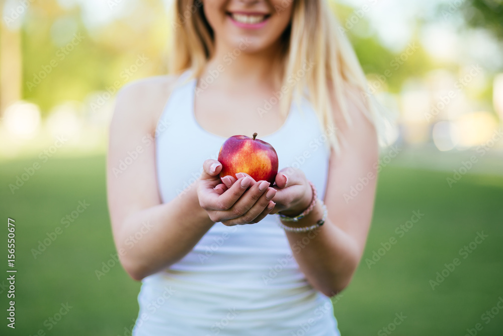 Beautiful attractive young holding fresh organic apple outdoors. Healthy lifestyle concept. Beautiful attractive young holding fresh organic apple outdoors. Healthy lifestyle concept.