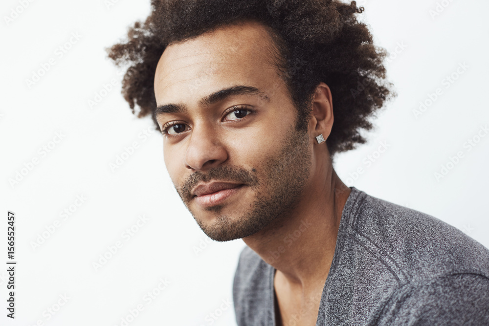 Obraz premium Portrait of handsome african man looking at camera over white background.