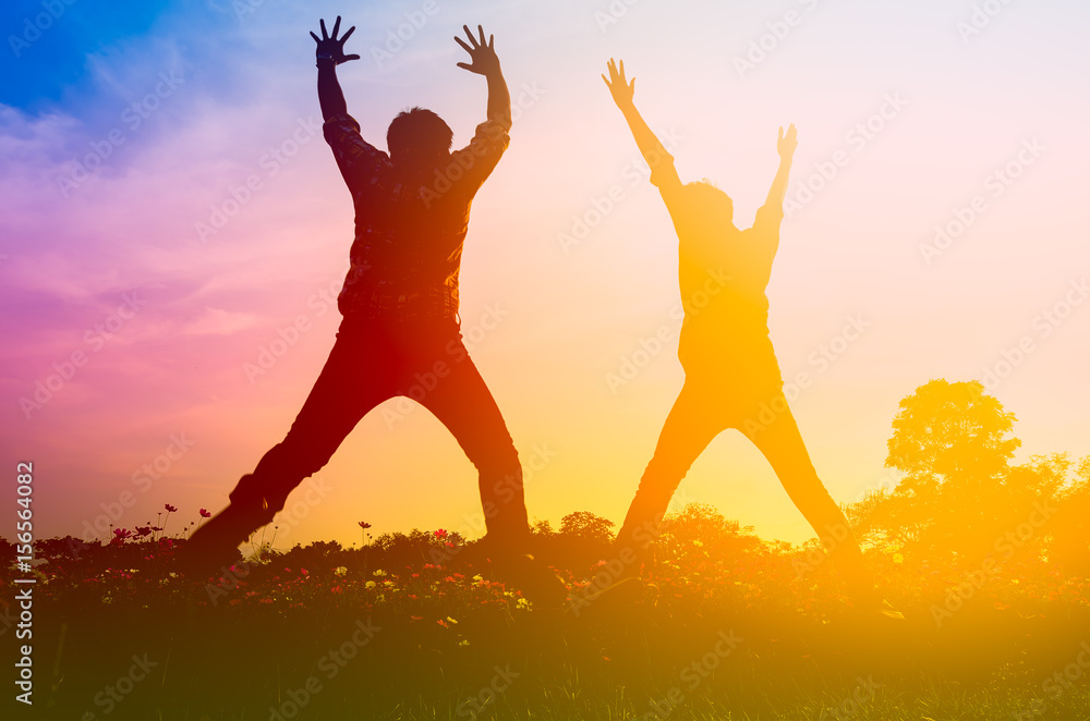 Silhouette look of two men happily jumping outdoor Silhouette look of two men happily jumping outdoor