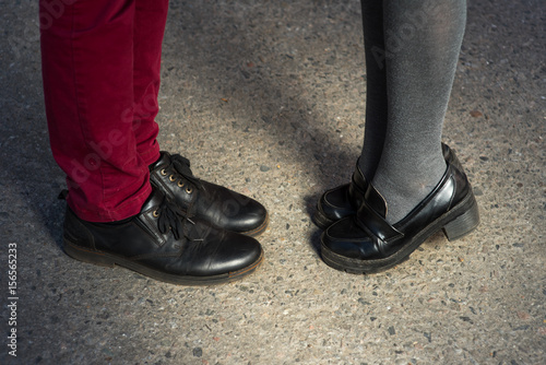 Love story told by boots. Human feet close up. Man and woman in elegand shoes. Girl in black shoes. Guy in black shoes and leather. Lady and gentleman couple in summer. Legs close up.
