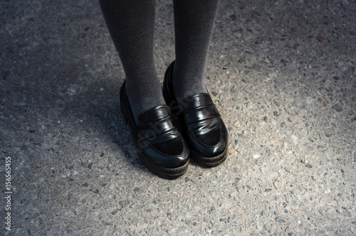 Retro Style Image Of School or student Girl's Feet In Uniform. black elegant shoes