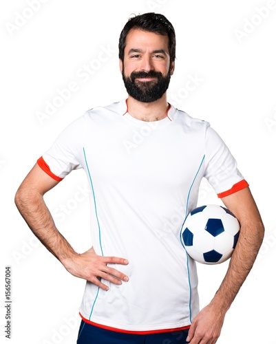 Happy football player holding a soccer ball