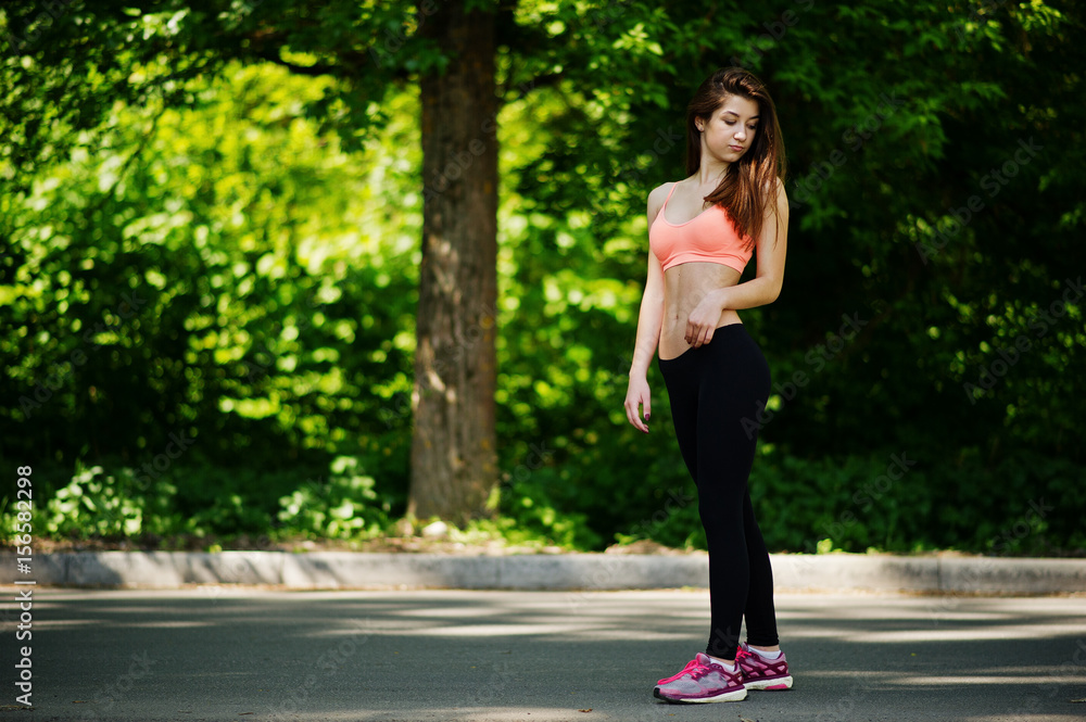 Fitness sport girl in sportswear posed at road in park, outdoor sports, urban style.