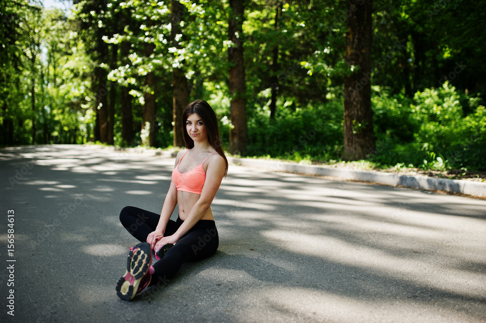 Fitness sport girl in sportswear sitting in road at park, outdoor sports, urban style. Fitness sport girl in sportswear sitting in road at park, outdoor sports, urban style.