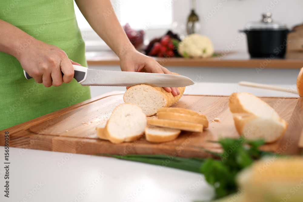 Close up of woman's hands cooking in the kitchen. Housewife slicing white bread. Vegetarian and healthily cooking concept