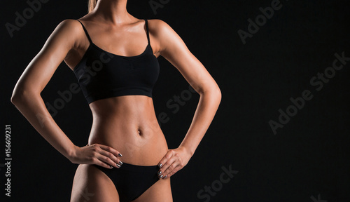 Muscular young woman athlete on black © master1305