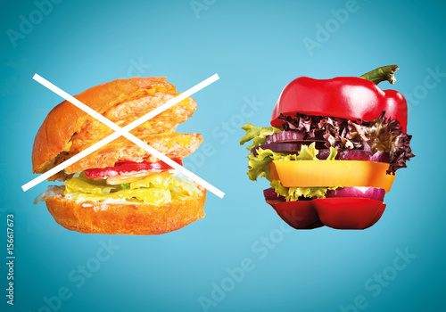 The healthy sandwich with fresh pepper, onion, salad lettuce and unhealthy harmful hamburger photo