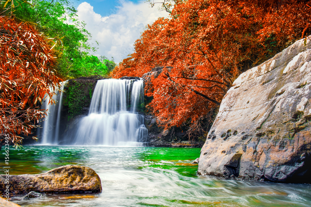 Fototapeta premium Waterfall in autumn forest and bule sky,Klong Chao Waterfall in Koh Kood island,Trat Thailand