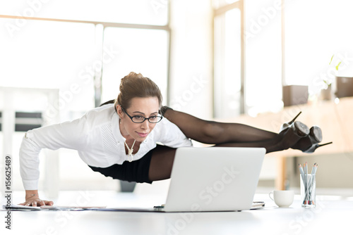 Happy woman doing exercises during working day photo
