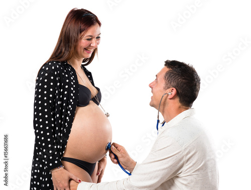 Husband  with stethoscope listeting his baby photo