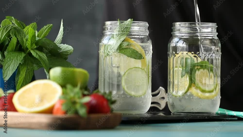 Homemade lemonade with lemon ,lime,mint and ice cubes on black background Homemade lemonade with lemon ,lime,mint and ice cubes on black background