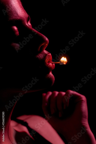 girl holding burning match in mouth