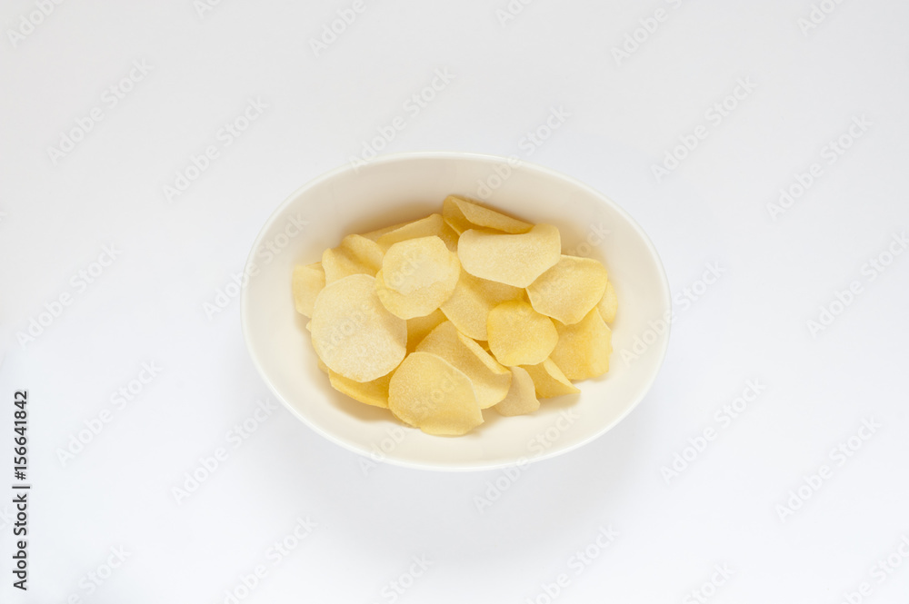 A cropped top view shot of a bowl with potato chips. A cropped top view shot of a bowl with potato chips.