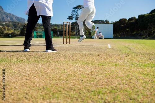 Close up of team playing cricket on pitch