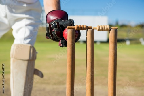 Close up of wicket keeper standing by stumps during match