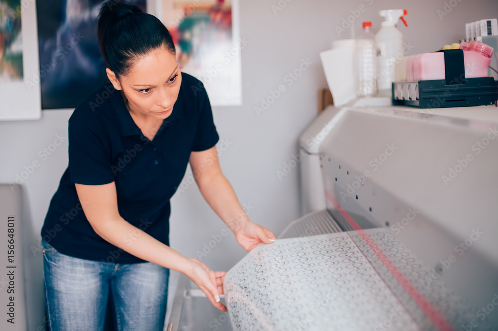 Fototapeta premium Technician working on plotter and cutter machine in printing centar