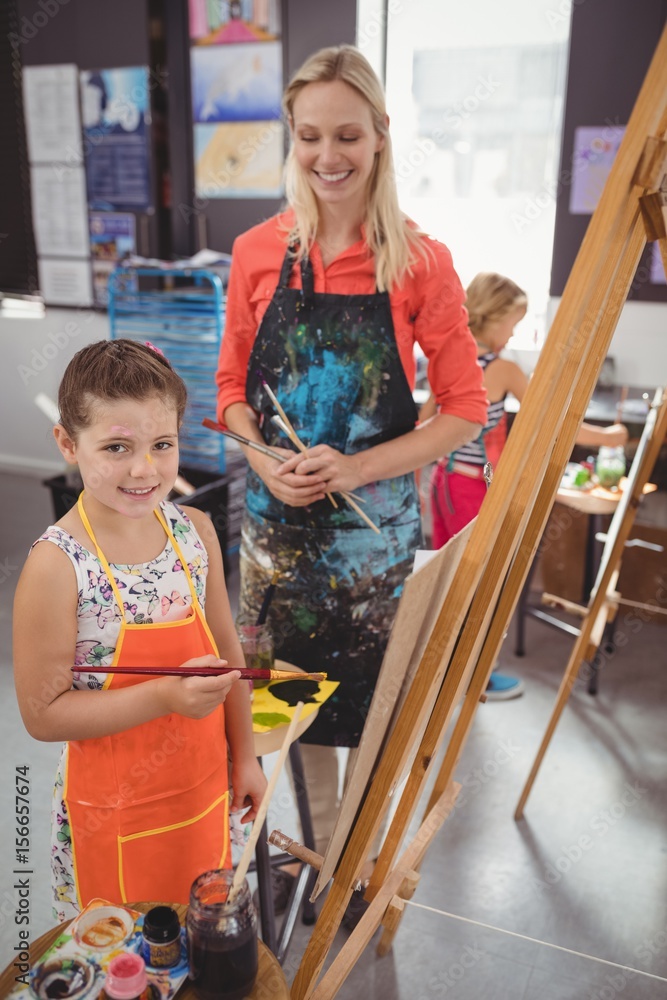 Obraz premium Teacher assisting girl in drawing class