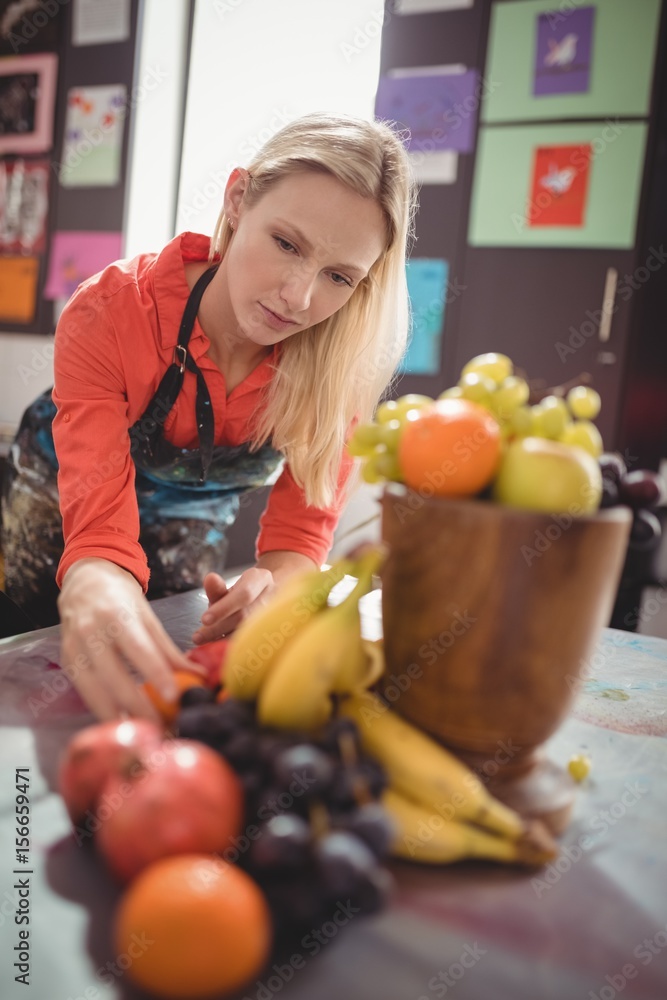 Teacher arranging food for painting on table Teacher arranging food for painting on table